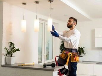Handyman installing pendant lights