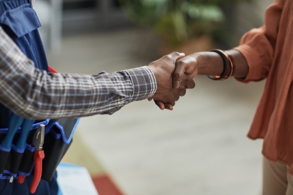 Construction worker and client shaking hands