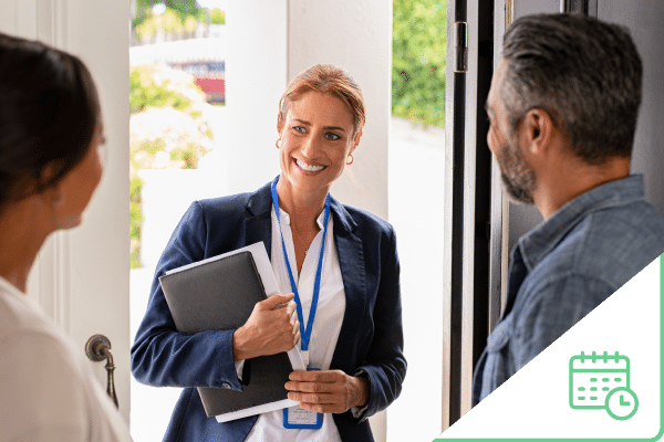 Woman consultant standing outside front door smiling at diverse couple