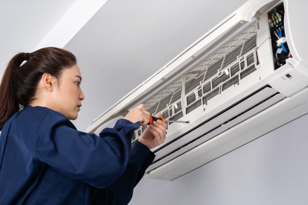 Woman construction worker fixing AC unit