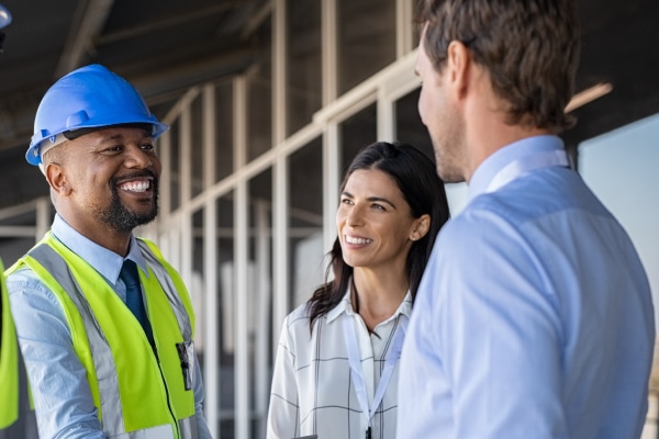 Diverse group of people speaking to construction worker